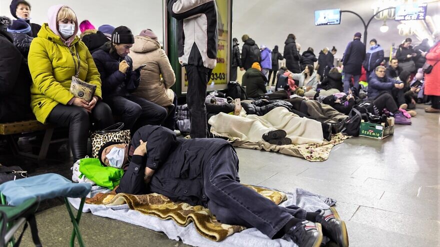 Ukrainians take refuge in a subway station that serves as a shelter for thousands of people during a rocket and bomb attack by Russian forces, February 2022. Credit: Drop of Light/Shutterstock.