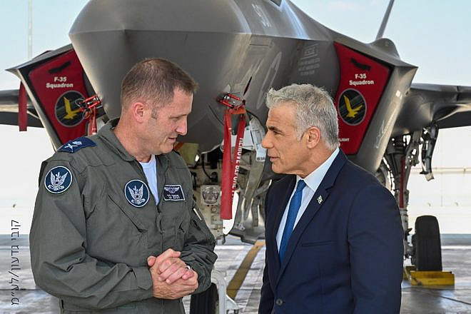 Israeli Air Force chief Brig. Gen. Tomer Bar speaks with Israeli Prime Minister Yair Lapid  at an air base in southern Israel, with an F-35 "Adir" fighter jet in the background. Credit: Kobi Gideon/GPO.
