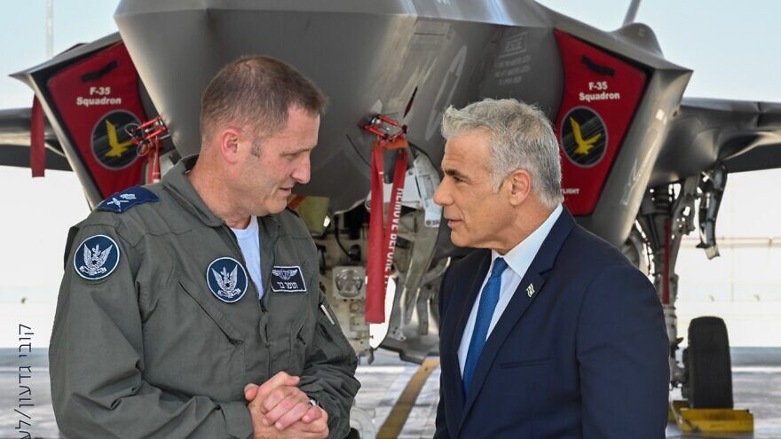 Israeli Air Force chief Brig. Gen. Tomer Bar speaks with Israeli Prime Minister Yair Lapid  at an air base in southern Israel, with an F-35 "Adir" fighter jet in the background. Credit: Kobi Gideon/GPO.