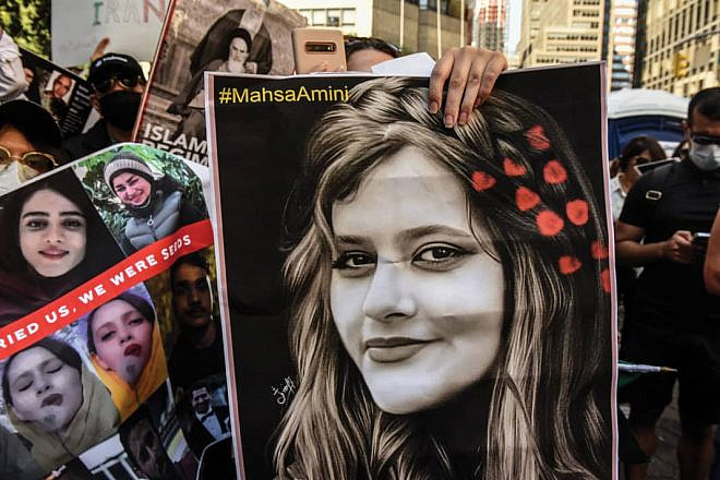 A protester holds a picture of Mahsa Amini, the Kurdish woman whose death in the custody of Iran’s “morality police” has sparked widespread unrest. Source: Twitter.