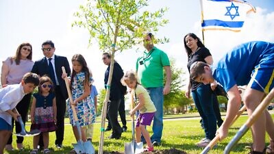A tree planting ceremony on Coushatta tribal lands, including Consul General of Israel to the Southwest U.S. Gilad Katz (third from right, wearing green) and his family. Credit: Alyssa Wallace.