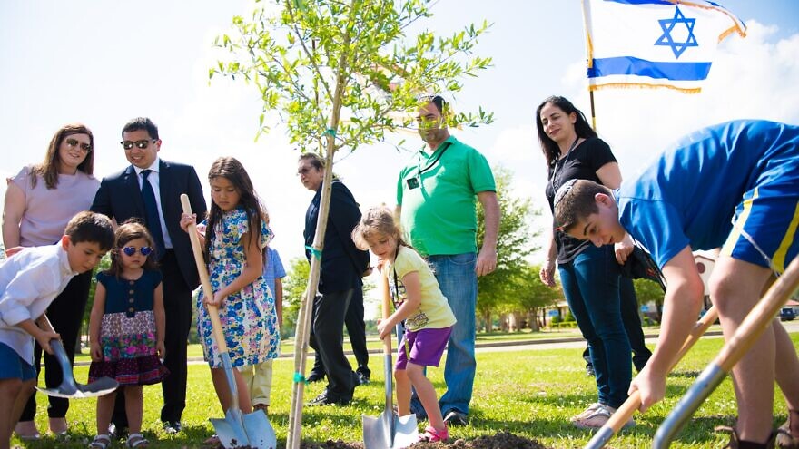 A tree planting ceremony on Coushatta tribal lands, including Consul General of Israel to the Southwest U.S. Gilad Katz (third from right, wearing green) and his family. Credit: Alyssa Wallace.