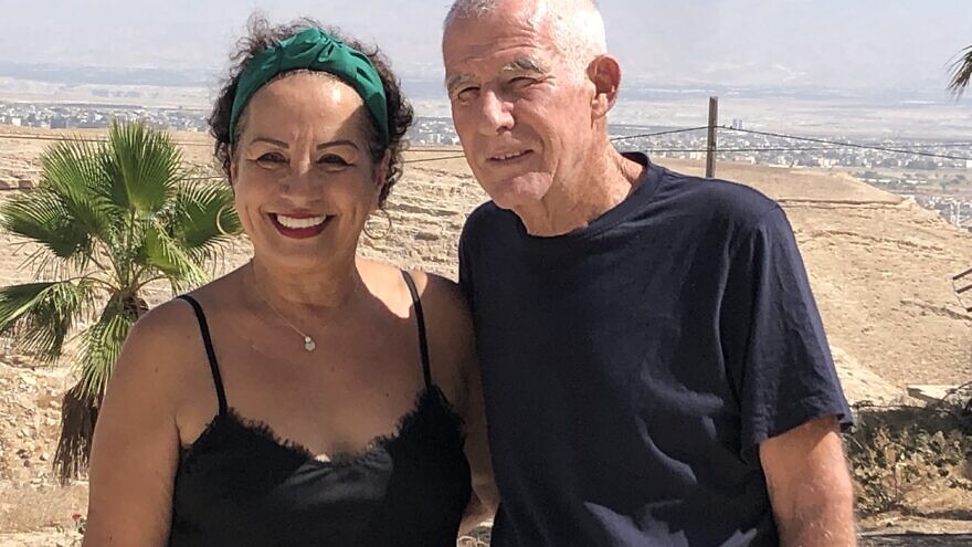 Lital and Zohar Aizenberg smile at their  Mi Casa Tu Casa bed and breakfast in Moshav Vered Yericho, with the city of Jericho in the background, Sept. 29, 2022. Credit: Josh Hasten.