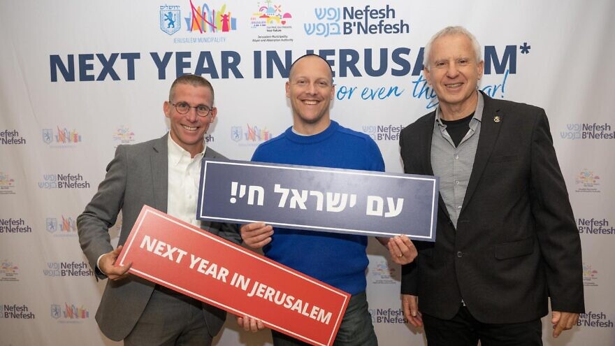 Nefesh B'Nefesh Executive Vice President Zev Gershinsky (left) and Pini Glinkewitz, director of the Aliyah and Integration Authority in the Jerusalem Municipality (right), with a potential immigrant. Photo by Shahar Azran.