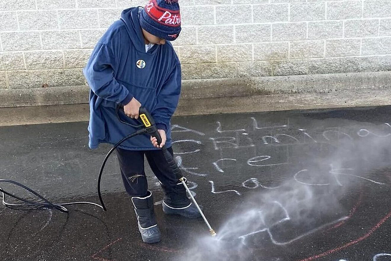Residents of Loudoun County clean up antisemitic and racist messages that were spray-painted in the South Riding area of the county. Credit: Facebook.