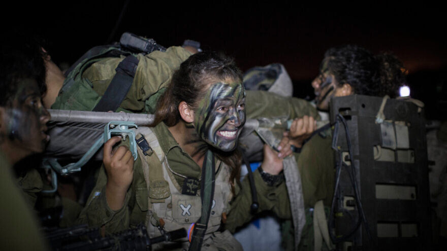 Soldiers in the Paran Brigade's Caracal Battalion carry a comrade on a stretcher towards the end of a 16 km. overnight hike to complete their basic training, in Tel Nitzan, near the border with Egypt, Sept. 3, 2014. Photo by Hadas Parush/Flash90.