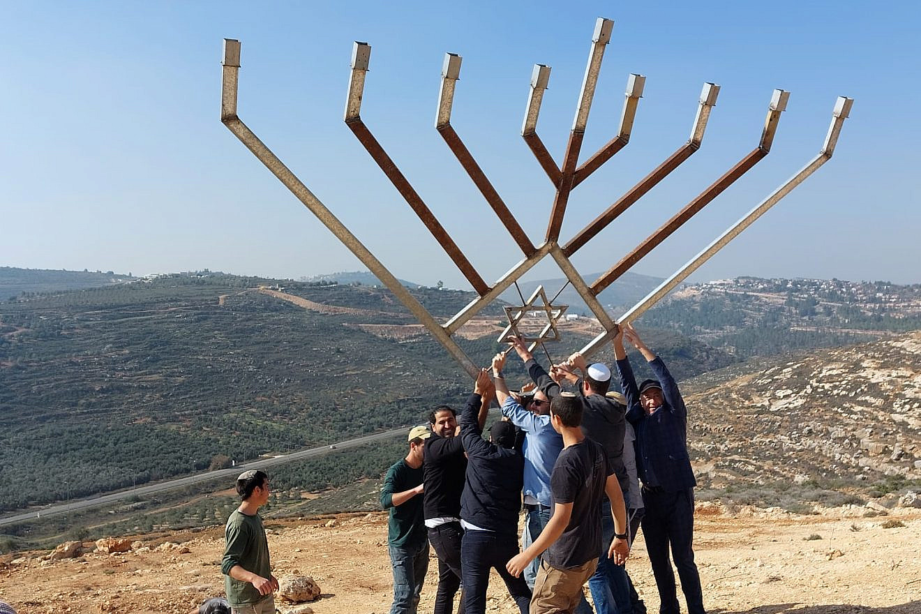 A delegation from Great Neck, N.Y., joins local youth to raise a large Chanukah menorah over the Shiloh Valley in Israel on Dec. 9, 2022. Credit: Courtesy of the Heartland Initiative.