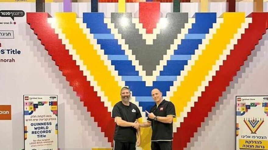 The massive LEGO menorah with Yitzchok Kasowitz (left), founder of Jbrick, and the manager of LEGO Store Tel Aviv. Source: Courtesy of Yitzchok Kasowitz.