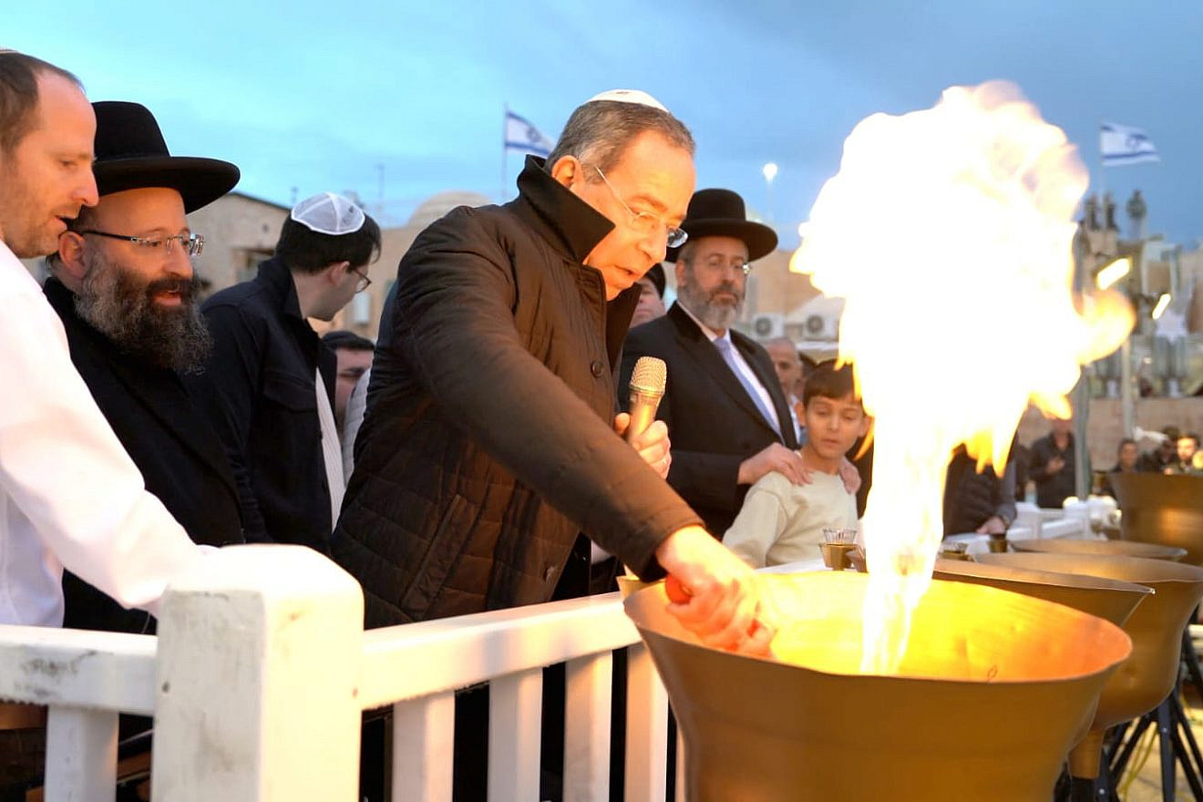 U.S. Ambassador Thomas Nides lights a Hanukkah flame at the Western Wall Plaza as Chief Rabbi of Israel David Lau (standing with the child) and Rabbi of the Western Wall and holy sites Shmuel Rabinowitz (directly behind Nides) look on, Dec. 25, 2022. Credit: The Western Wall Heritage Foundation.