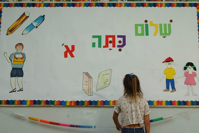 A small child reads a board welcoming her to the first grade at Pola Ben-Gurion School in Jerusalem, Aug. 31, 2004. Credit: Flash90.
