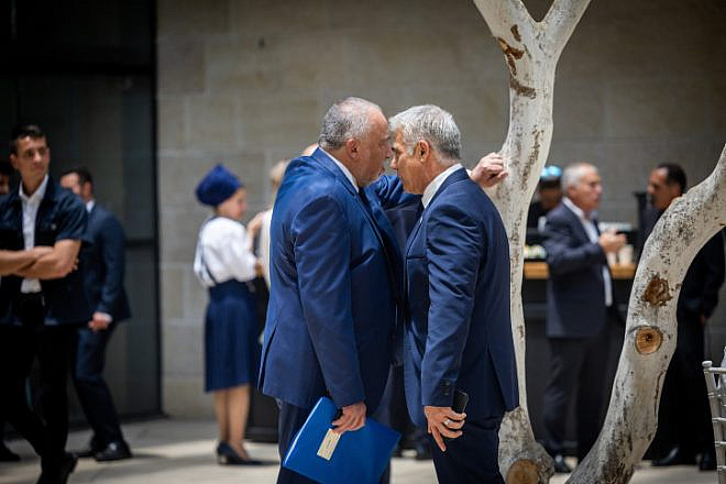 Now-former Finance Minister Avigdor Liberman and then-Foreign Minister Yair Lapid greet at a conference at the Givat Ram campus of the Hebrew University in Jerusalem, May 29, 2022. Photo by Yonatan Sindel/Flash90.