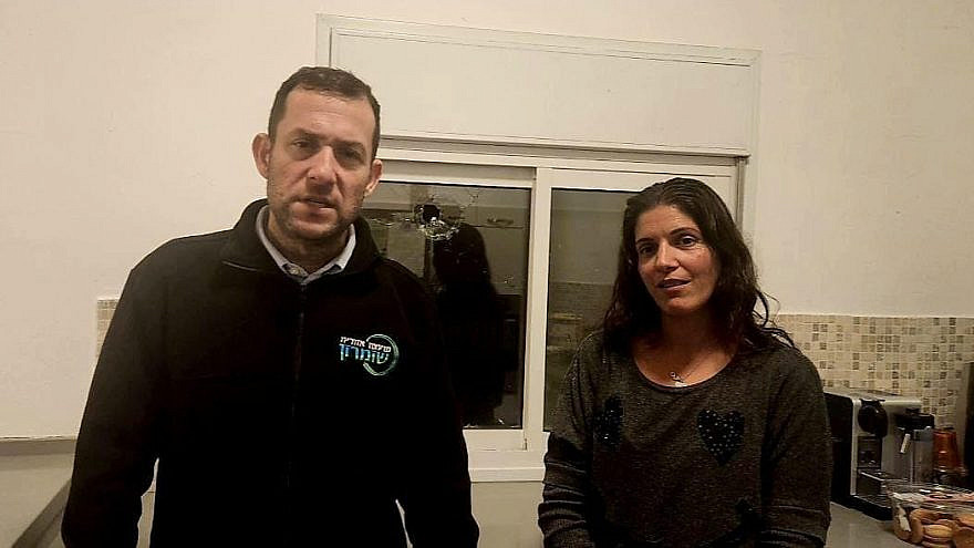 Samaria Regional Council head Yossi Dagan and Shaked resident Limor Merom, Jan. 15, 2023. Visible in the background is a hole in Merom's kitchen window made by a bullet fired by Palestinian terrorists. Credit: Samaria Regional Council.