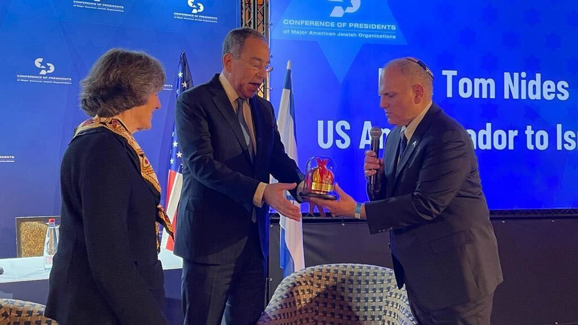 William Daroff, CEO of Conference Presidents of Major American Jewish Organizations, presents U.S. Ambassador to Israel Thomas Nides with a gift while Conference of Presidents chair Dianne Lob looks on. Photo by Alex Traiman.