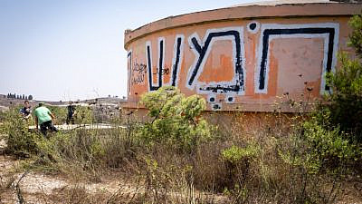 Visitors walk by the water tower in the ruins of the former community of Homesh, Aug. 27, 2019. Photo by Hillel Maeir/Flash90.