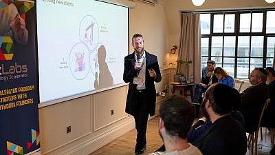 Israel Levkivker, co-founder of Massdom, presents his company at a Bizmax “scalerator” event for haredi tech business leaders at Mortimer House in London on March 20, 2023. Photo by Dudy Braun.
