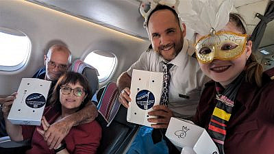 Arkia flight attendants hand out Purim gift packages to passengers, March 2023. Credit: Arkia Israeli Airlines.