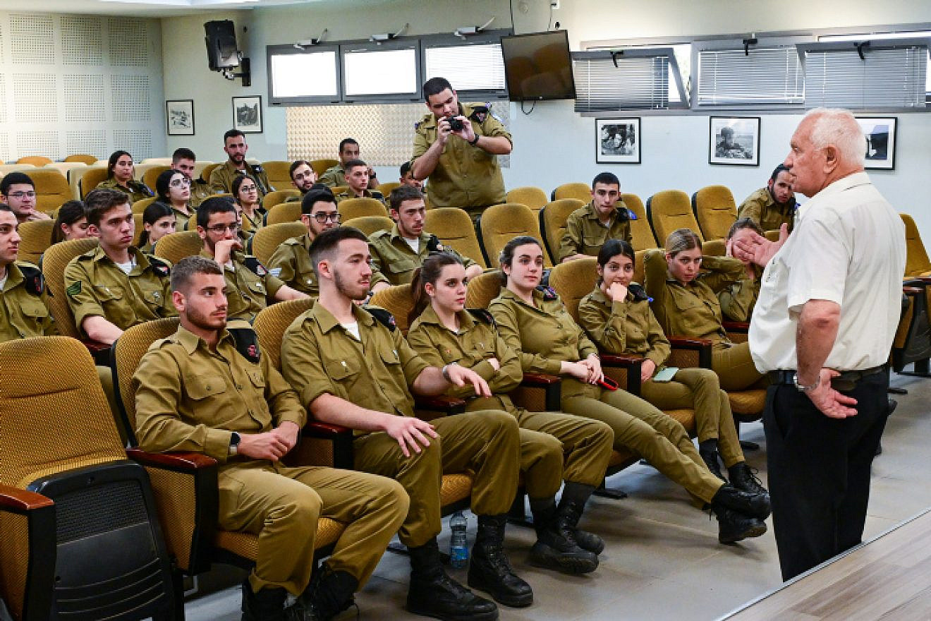 Soldiers from the IDF's 7th Armored Brigade listen to 82-year-old Holocaust survivor Haim Grinberg on the Golan Heights, April 17, 2023. Photo by Michael Giladi/Flash90.