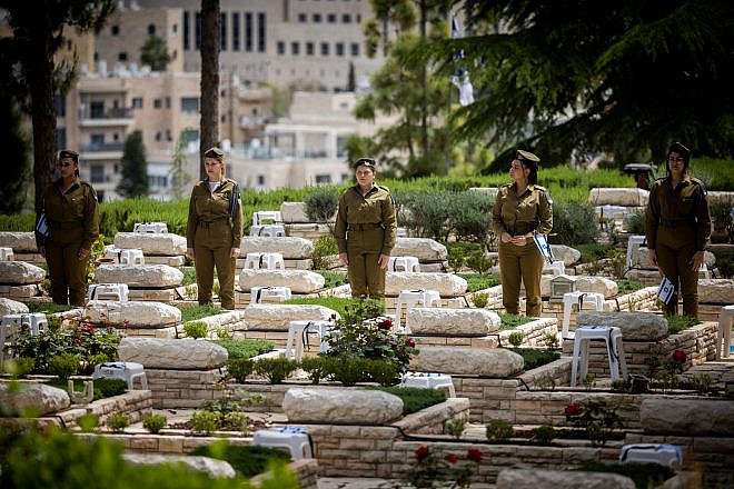 Soldiers place flags on the graves of fallen comrades at Mount Herzl Military Cemetery in Jerusalem, April 23, 2023. Photo by Yonatan Sindel/Flash90.