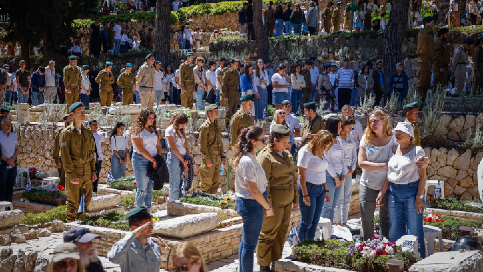 Israelis stand in silence next to the graves of soldiers in the Mount Herzl military cemetery in Jerusalem, as a two-minute siren sounds across the country on Memorial Day, April 25, 2023. Photo by Erik Marmor.