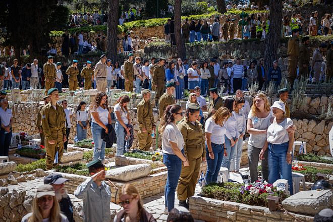 Israelis stand in silence next to the graves of soldiers in the Mount Herzl military cemetery in Jerusalem, as a two-minute siren sounds across the country on Memorial Day, April 25, 2023. Photo by Erik Marmor.