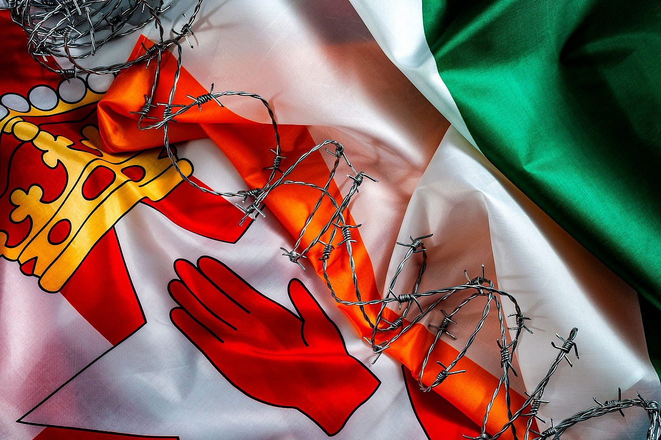 The Good Friday Agreement, and hard border between Northern Ireland and the Republic of Ireland, as a result of Brexit concept with the flags of of both Irish countries separated by barbwire. Credit: Victor Moussa/Shutterstock.