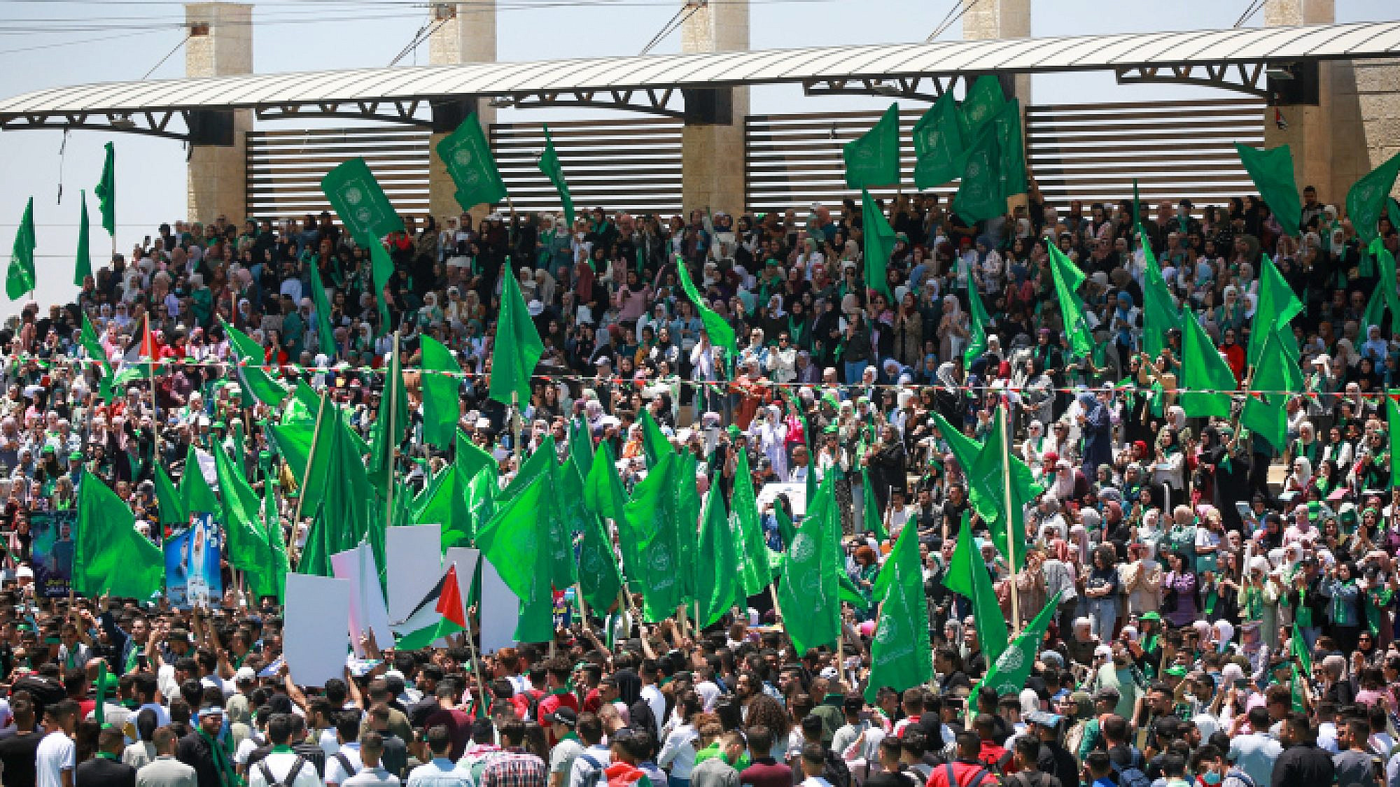 Hamas supporters wave the terrorist movement's flag during a student rally at Birzeit University, near Ramallah, May 19, 2022. Credit: Flash90.