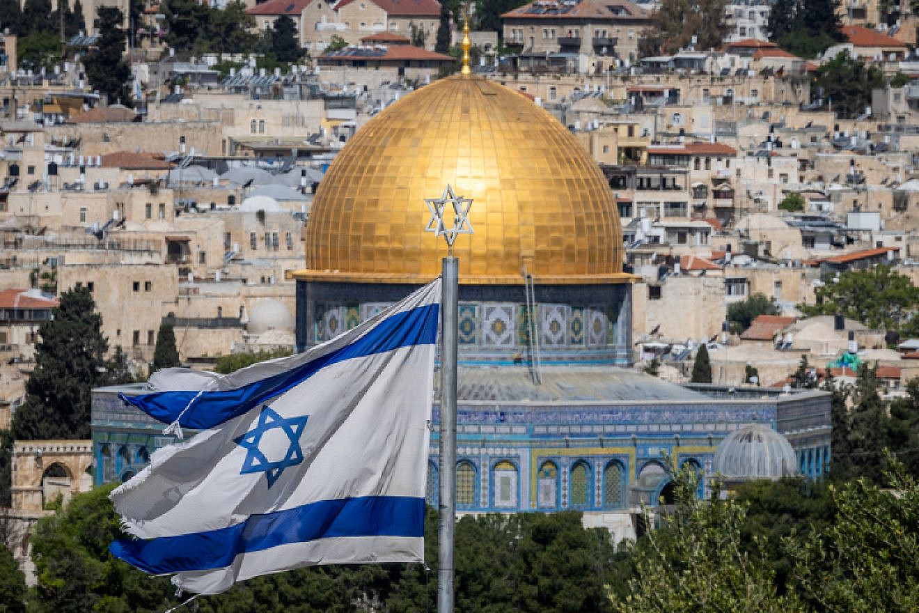 An Israeli flag, with the Dome of the Rock in Jerusalem's Old City in the background, as seen from the Mount of Olives observatory, on April 24, 2023. Photo by Yonatan Sindel/Flash90.