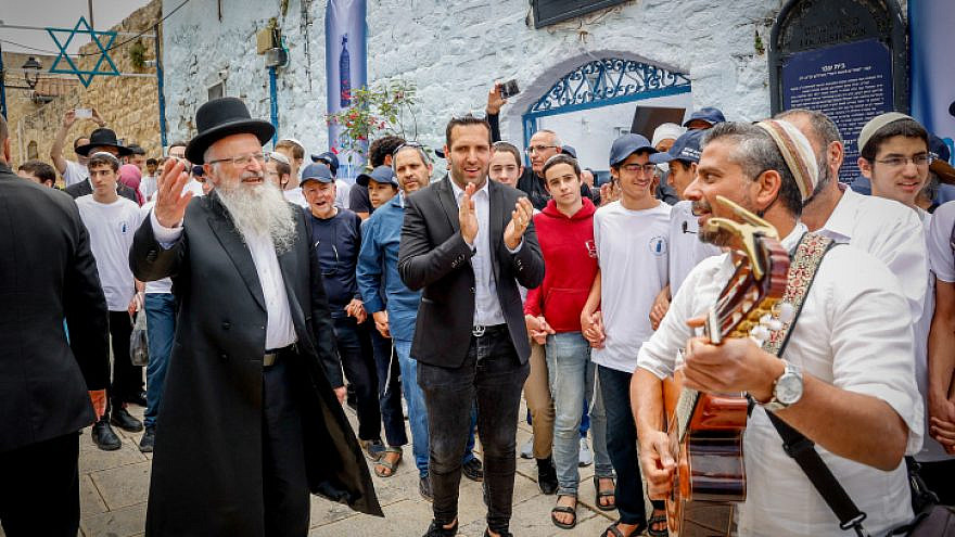 Le maire de Tzfat, Shuki Ohana, et le grand rabbin Shmuel Eliyahu dansent lors de l'ouverture des célébrations de Lag Baomer dans la ville de Galilée, le 8 mai 2023. Photo de Gershon Elinson/Flash90.