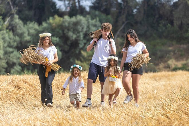 Young Israelis from Ben Shemen pose for a picture in a harvest field ahead of Shavuot, on May 18, 2023. Photo by Yossi Aloni/Flash90.