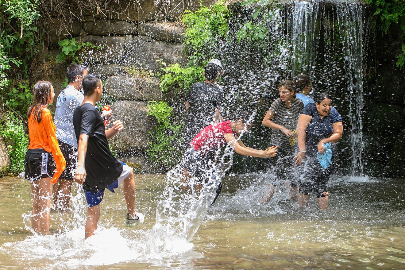Israelis play in the springs and waterfalls of Snir Park in the Snir Valley, near the Jordan River, May 22, 2023. Photo: Ayal Margolin/FLASH90