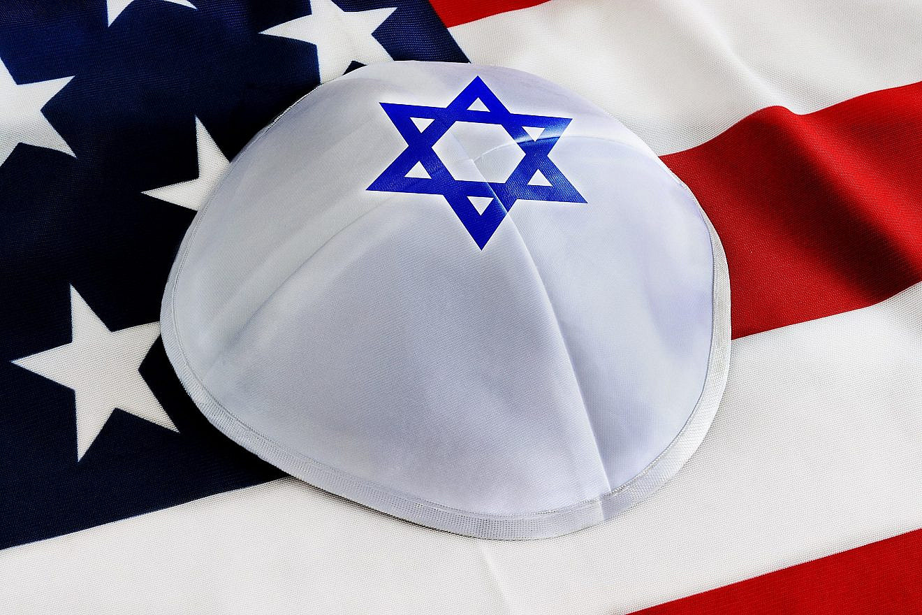 Kippah or yarmulke on the background of the American Flag. Credit: Shabtay/Shutterstock.