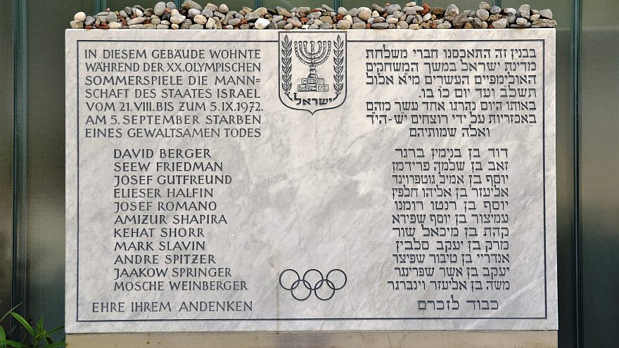 A plaque in front of the Israeli athletes' quarters commemorates the victims of the 1972 Munich Olympics massacre. The inscription, in German and Hebrew, reads: “The team of the State of Israel lived in this building during the 20th Olympic Summer Games from 21 August to 5 September 1972. On 5 September, [list of victims] died a violent death. Honor to their memory.” Credit: Wikimedia Commons.