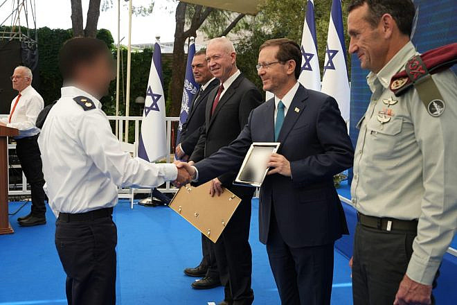 President Isaac Herzog, with Defense Minister Yoav Gallant to his right and IDF Chief of Staff Lt. Gen. Herzi Halevi to his left, hands an award to one of the winners. Credit: Ministry of Defense Spokesperson’s Office.