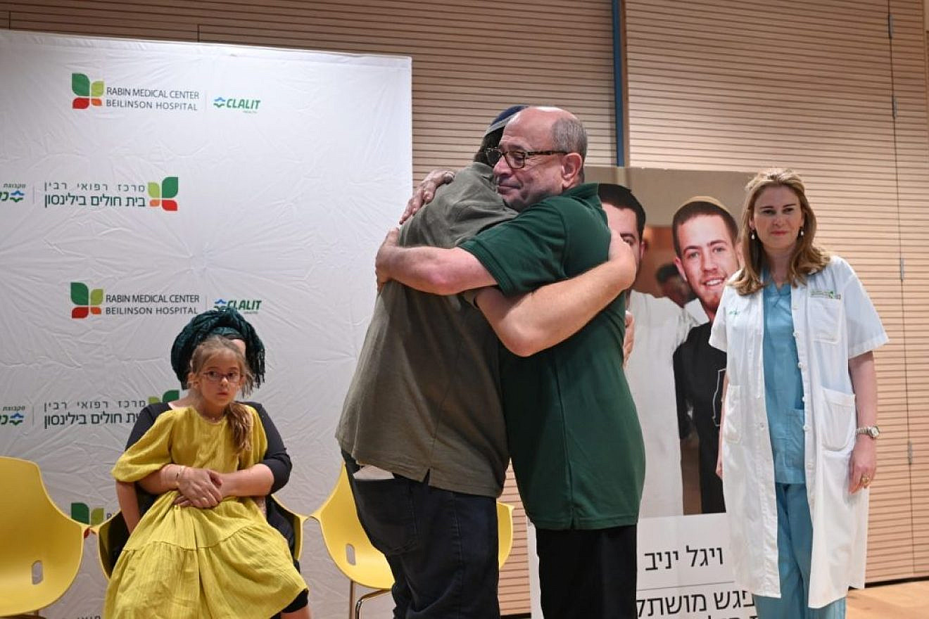 Shalom Yaniv (left), father of terror victims Hallel and Yagel Yaniv, hugs Ron Carmeli, who received a donated cornea, at Beilinson Hospital in Petach Tikvah, June 18, 2023. Photo by Yossi Zeliger/TPS.