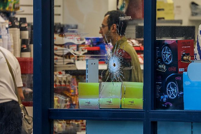 A bullet hole through the window of a convenience store after an attack in the Jewish community of Eli that left four Israelis dead and others injured, June 20, 2023. Photo by Flash90.