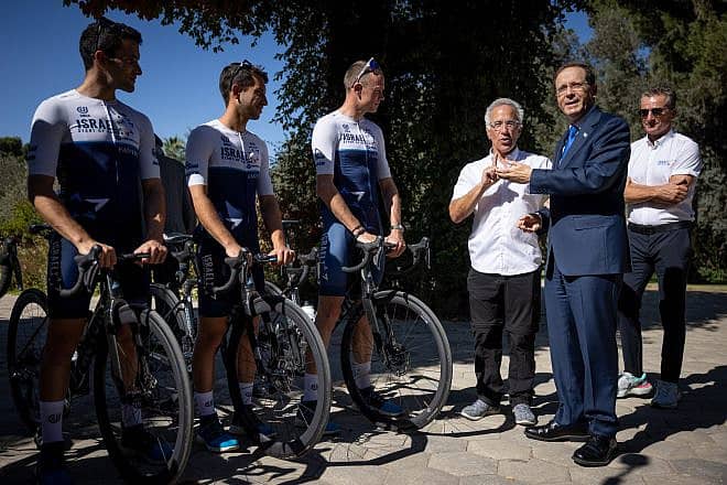 Israeli President Isaac Herzog (wearing a suit) hosts British cyclist Chris Froome (third from the left) and Israel-Premier Tech co-owner Sylvan Adams (standing between them) at the President's Residence in Jerusalem, Nov. 7, 2021. Photo by Yonatan Sindel/Flash90.