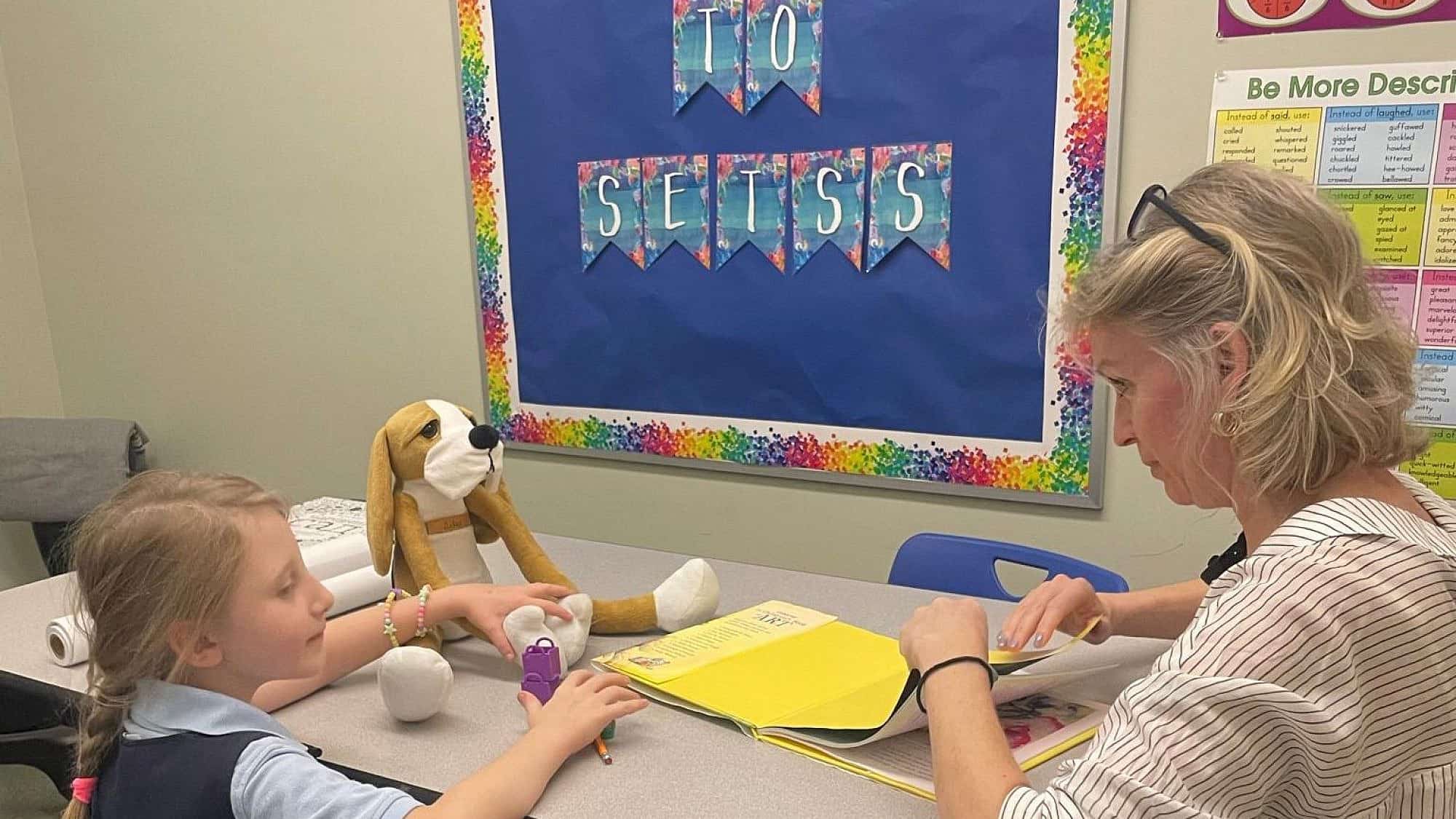 Inna Muntyan, an educational interventionist at Hebrew Language Academy in Brooklyn, N.Y., works with Polina, a refugee from Ukraine, with a Hibuki therapy doll. Credit: Courtesy.