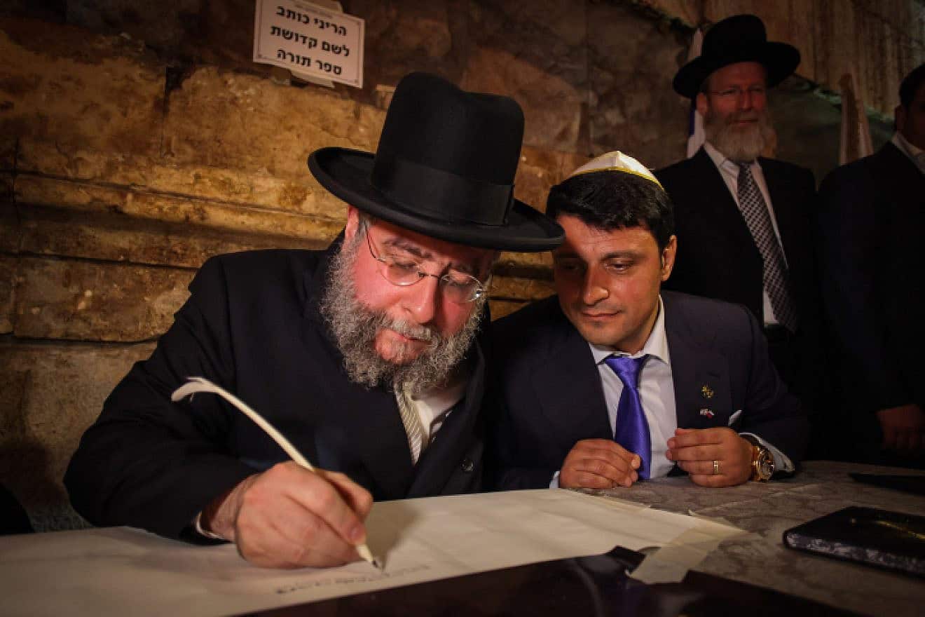 Then-Chief Rabbi of Moscow Pinchas Goldschmidt helps to write a new Torah scroll in the Western Wall tunnels in Jerusalem, May 21, 2014. Photo by Flash90.