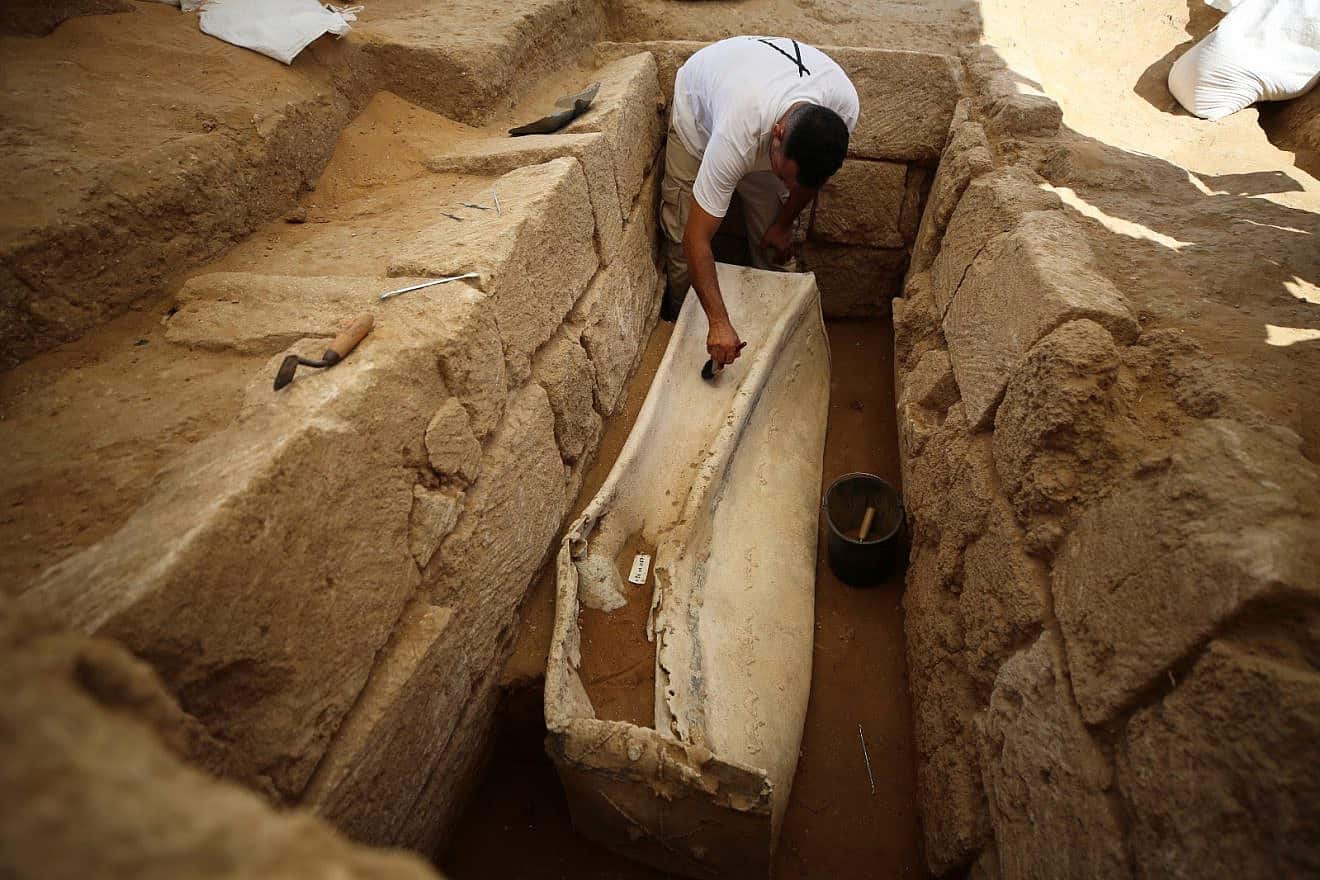 A Palestinian archaeologist works on a 2,000 year-old lead sarcophagus discovered during the excavation of a Roman cemetery in the northern Gaza Strip, July 16, 2023. Photo by Majdi Fathi/TPS.