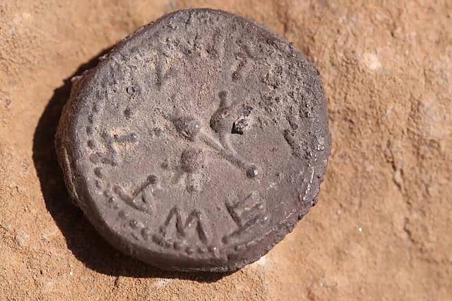 A 2,000-year-old coin discovered at the entrance to a cave in the Judean Desert, bearing an inscription reading "Holy Jerusalem" in ancient script. Credit: Emil Aladjem/IAA.