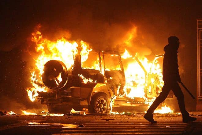 A burning car during riots in Paris, France. Photo: Bumble Dee/Shutterstock.