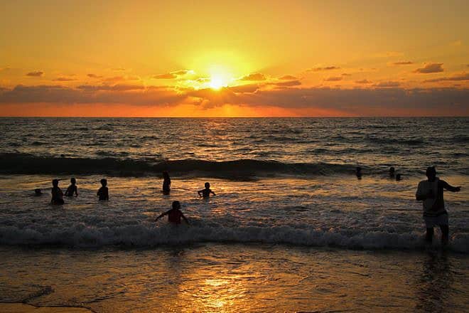 People enjoy themselves at Nitzanim Beach, between Ashdod and Ashkelon, Aug. 9, 2023. Photo by Gershon Elinson/Flash90.