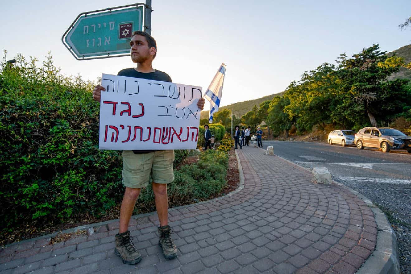 An Israeli protests against the visit of Israeli Prime Minister Benjamin Netanyahu and his wife, Sara, at Moshav Neve Ativ, Aug. 7, 2023. Photo by Ayal Margolin/Flash90.