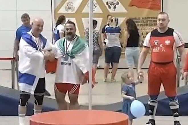 Iranian weightlifter Mostafa Rajaei (center) shakes the hand of Israeli weightlifter Maksim Svirsky at an event in Poland, Aug. 26, 2023. Source: