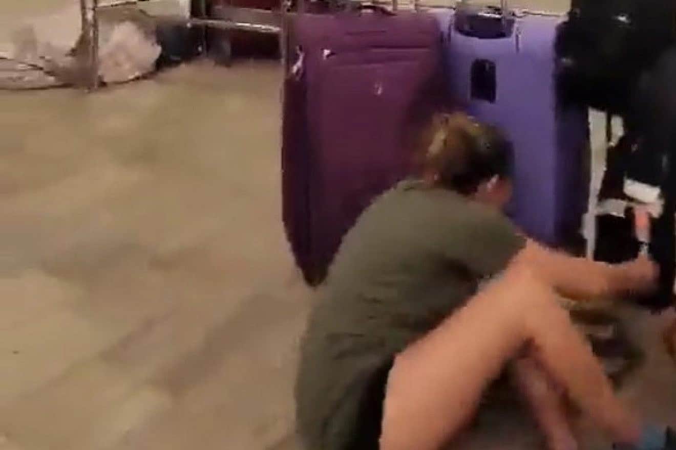 A passenger at Ben Gurion Airport hides behind suitcases during a security incident, Aug. 31, 2023. Source: Twitter/X.