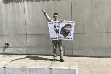 While Jews were observing Yom Kippur, this man and another older man stood in front of the Dallas Holocaust Museum holding antisemitic posters, Sept. 25, 2023. Source: StopAntisemitism.