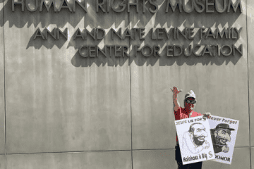 While Jews were observing Yom Kippur, this man and another younger man stood in front of the Dallas Holocaust Museum holding antisemitic posters, Sept. 25, 2023. Source: StopAntisemitism.