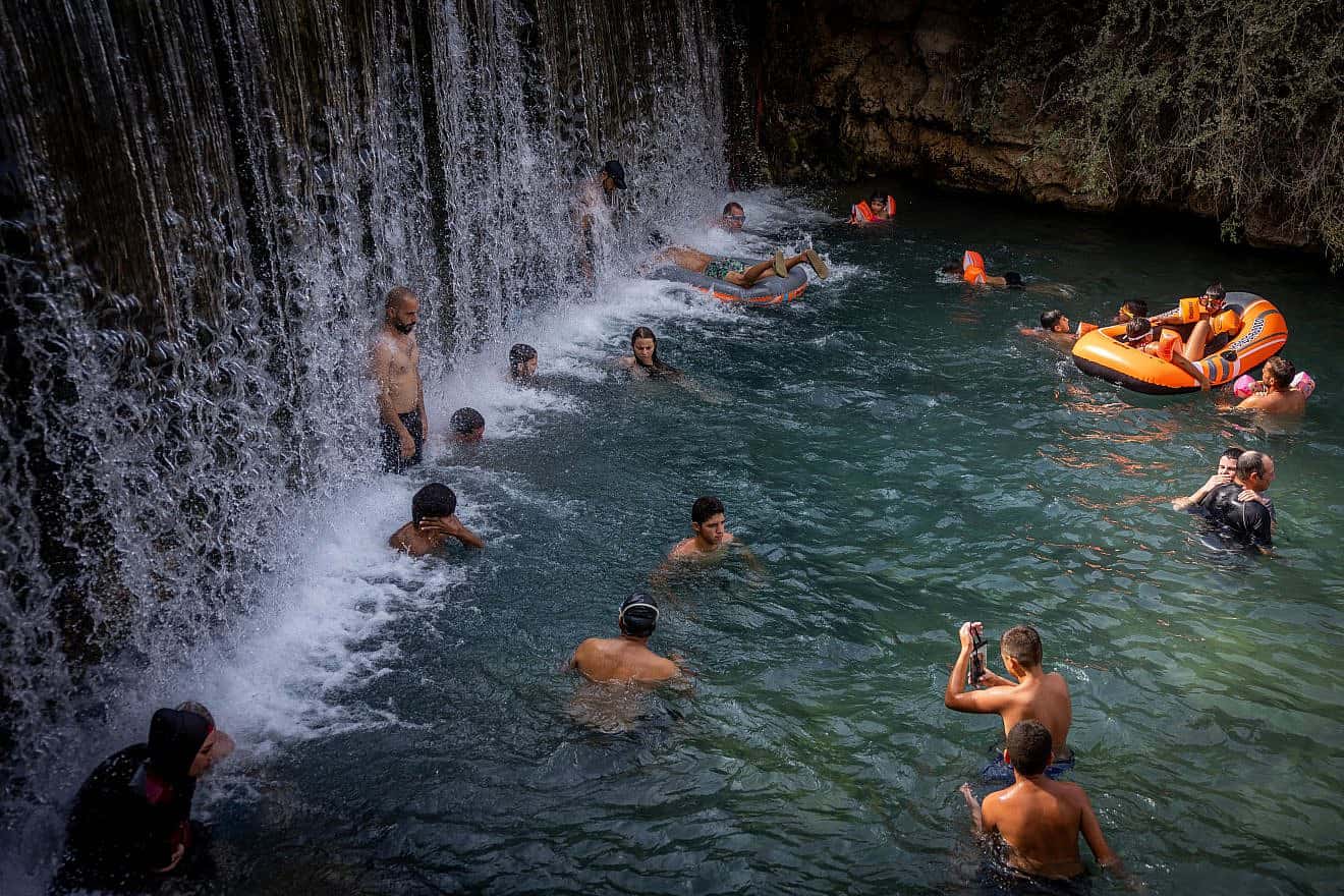 People enjoy the water in Gan Hashlosha National Park, aka Sakhne, in the Beit She'an Valley, during an extreme heat wave, Aug. 13, 2023. Photo by Yonatan Sindel/Flash90.