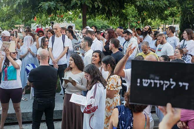 Activists protest against gender segregation (the sign in Hebrew can be translated as“Enough with the sanctification”) in the public space during a prayer on Dizengoff Square in Tel Aviv on Yom Kippur, the Day of Atonement, on Sept. 25, 2023. Photo by Itai Ron/Flash90.