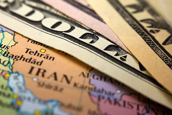 Dollar bills on top of a map of Iran. Credit: corlaffra/Shutterstock.